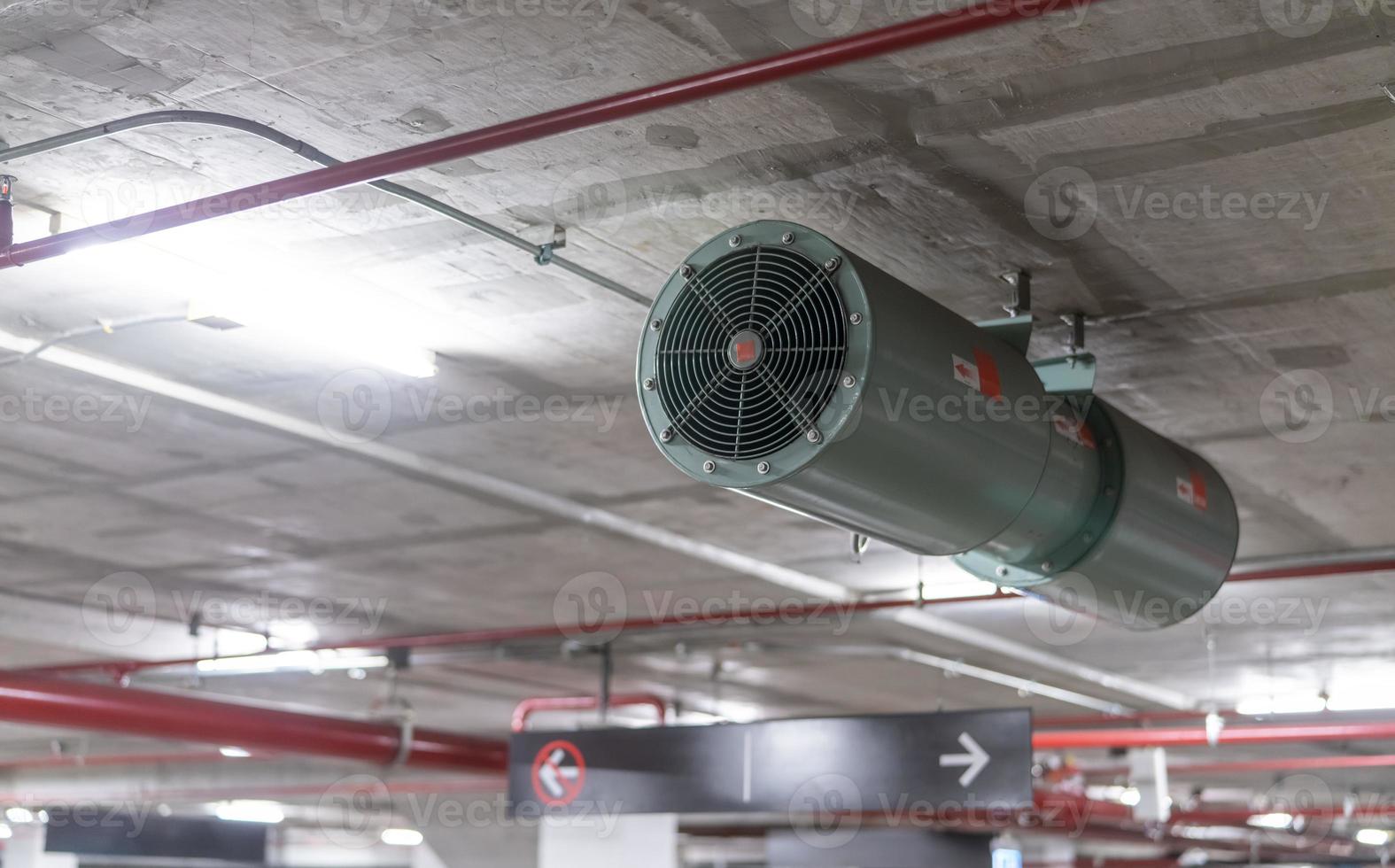 Jet fan at underground parking area. Ventilation fan in the parking lot. Air flow system. Ventilation system in underground car parking lot at commercial building. Duct fan air ventilation at mall. photo