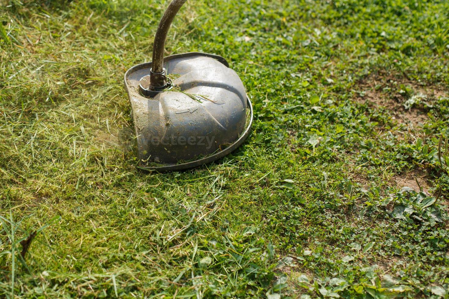 a man mows grass with a trimmer outdoor photo