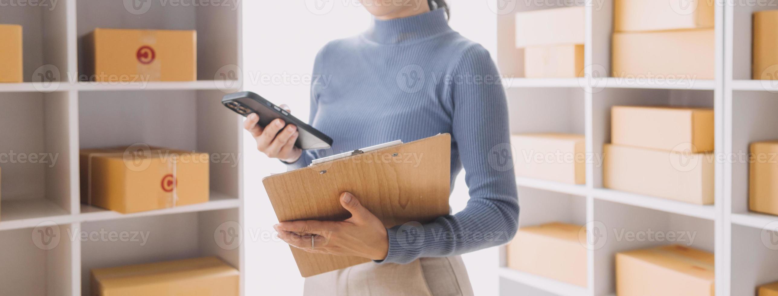 Entrepreneurs Small Business SME Independent men work at home Use smartphones and laptops for commercial checking, online marketing, packing boxes, SME sellers, concept, e-commerce team, online sales photo