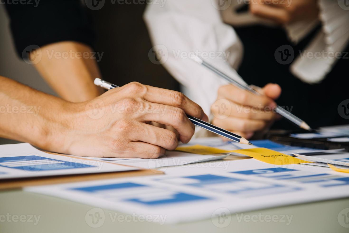 Close up ux developer and ui designer brainstorming about mobile app interface wireframe design on table with customer breif and color code at modern office.Creative digital development agency photo