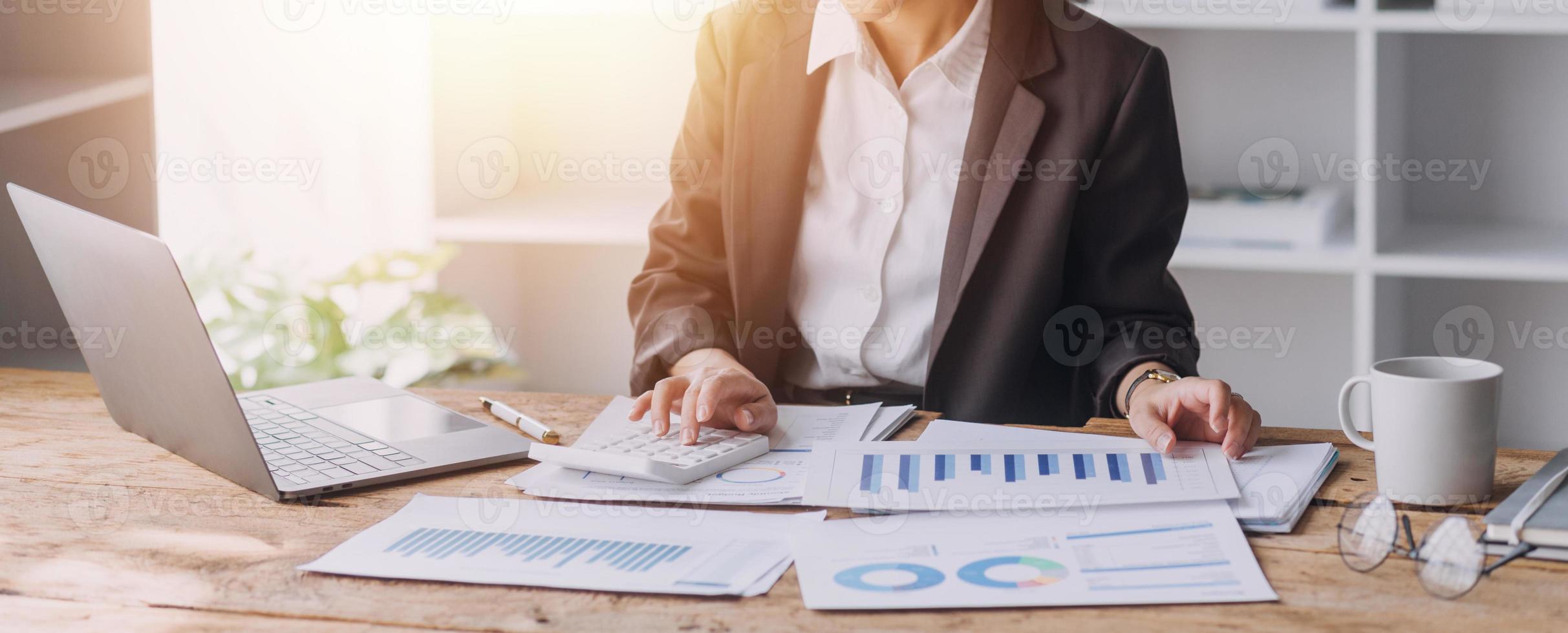 Businesswoman or accountant working Financial investment on calculator, calculate, analyze business and marketing growth on financial document data graph, Accounting, Economic, commercial concept. photo