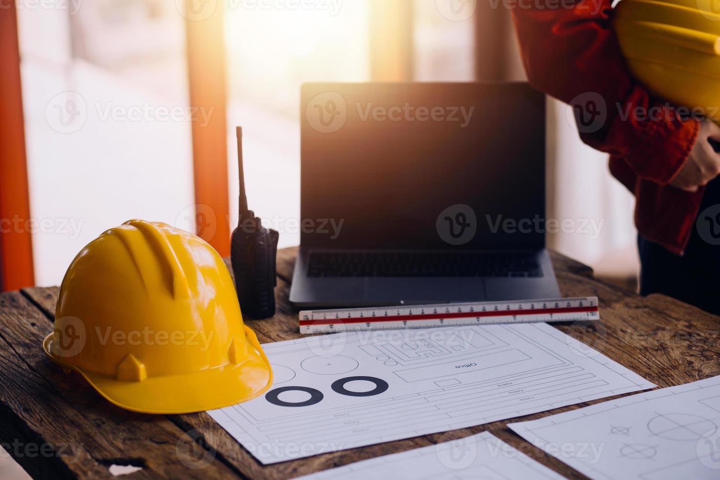 Three colleagues discussing data working and tablet, laptop with on on architectural project at construction site at desk in office photo
