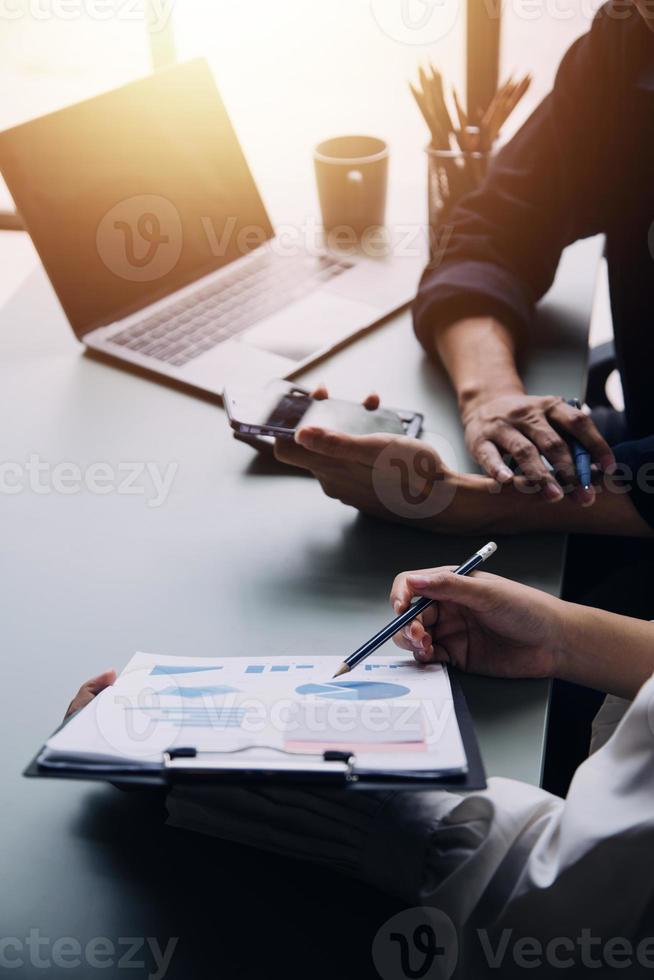 Group of confident business people point to graphs and charts to analyze market data, balance sheet, account, net profit to plan new sales strategies to increase production capacity. photo