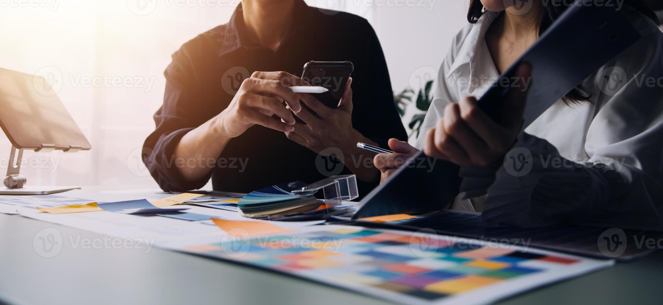 Close up ux developer and ui designer brainstorming about mobile app interface wireframe design on table with customer breif and color code at modern office.Creative digital development agency photo
