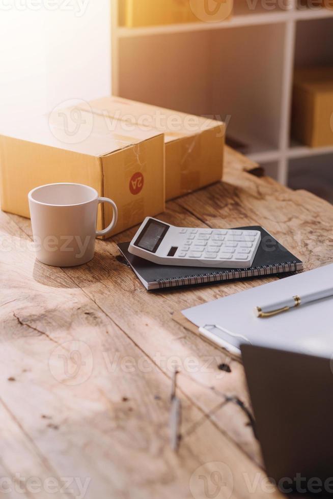 Entrepreneurs Small Business SME Independent men work at home Use smartphones and laptops for commercial checking, online marketing, packing boxes, SME sellers, concept, e-commerce team, online sales photo