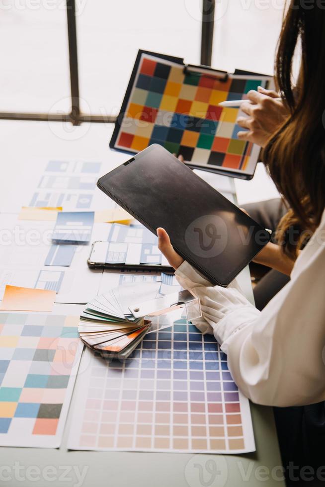 Close up ux developer and ui designer brainstorming about mobile app interface wireframe design on table with customer breif and color code at modern office.Creative digital development agency photo