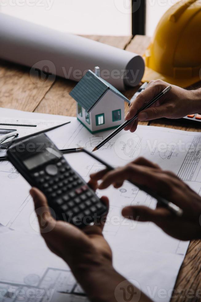 Image of engineering objects on workplace with three partners interacting on background photo