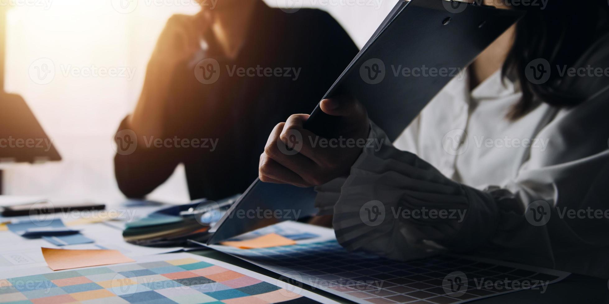 Close up ux developer and ui designer brainstorming about mobile app interface wireframe design on table with customer breif and color code at modern office.Creative digital development agency photo