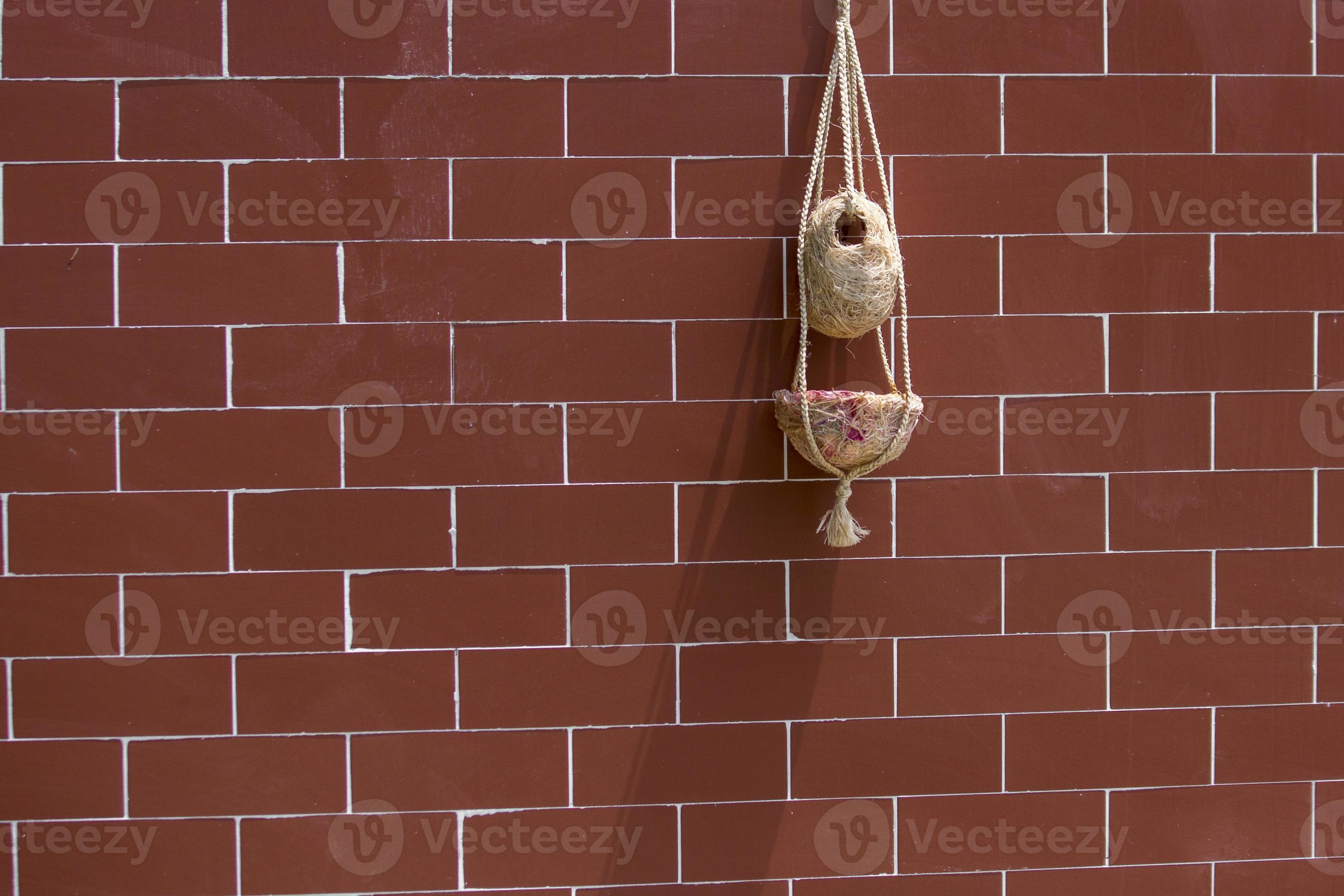 Handmade birds nest are hanging on the bricks wall. Interior Decoration