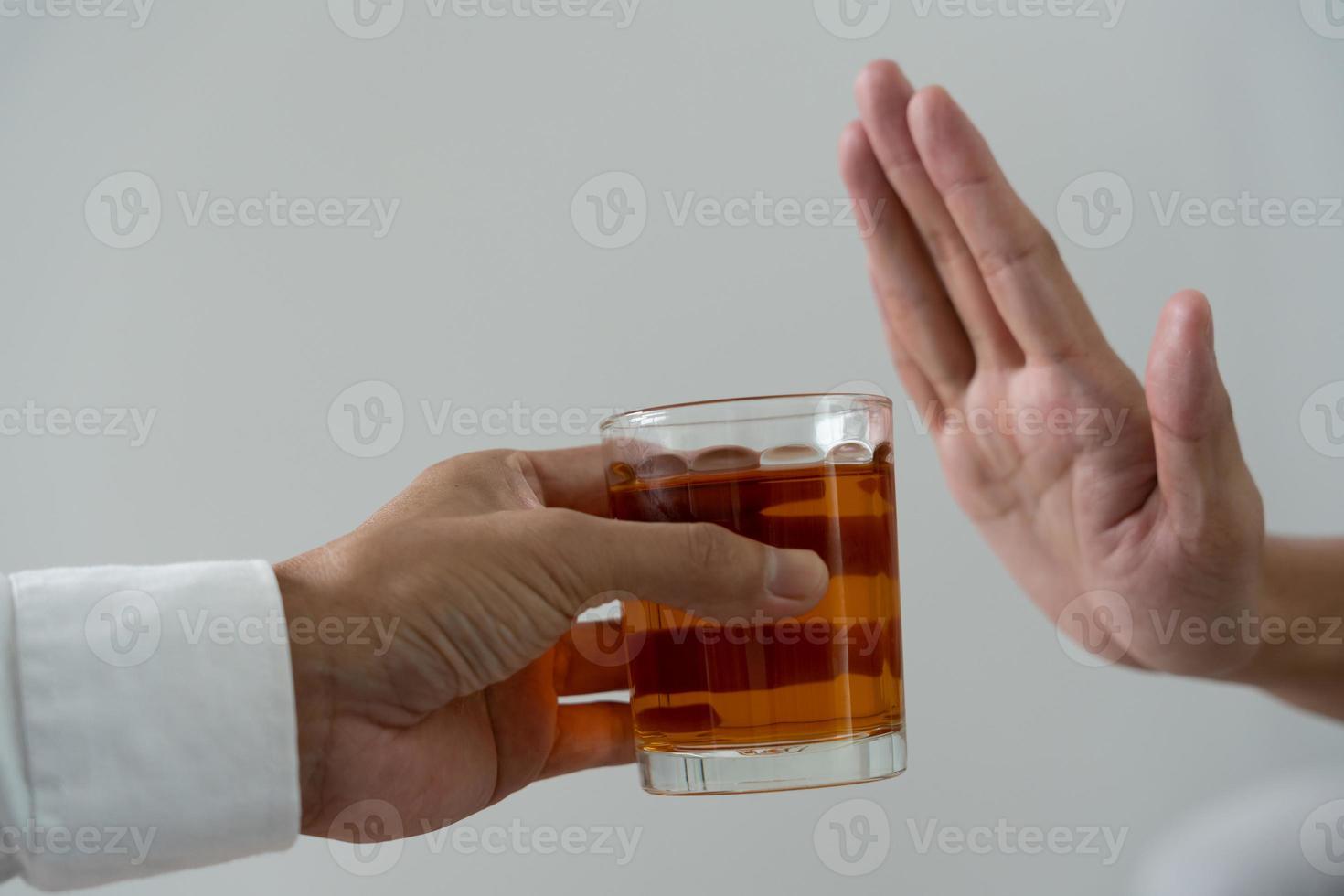 man refuses say no and avoid to drink an alcohol whiskey , stopping hand sign male, alcoholism treatment, alcohol addiction, quit booze, Stop Drinking Alcohol. Refuse Glass liquor, unhealthy, reject photo