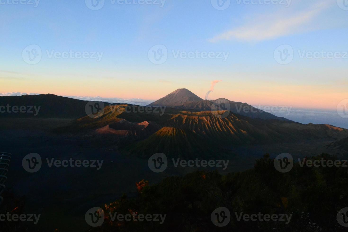 View of Mount Bromo in the morning with the peaks of Mount Semeru in the background photo