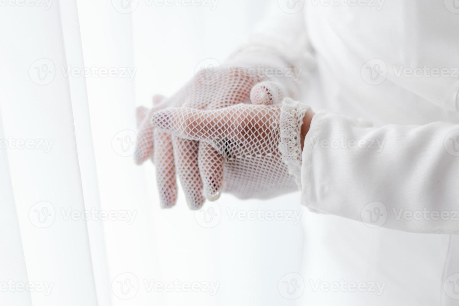 A woman wearing a white glove is wearing a white glove. photo