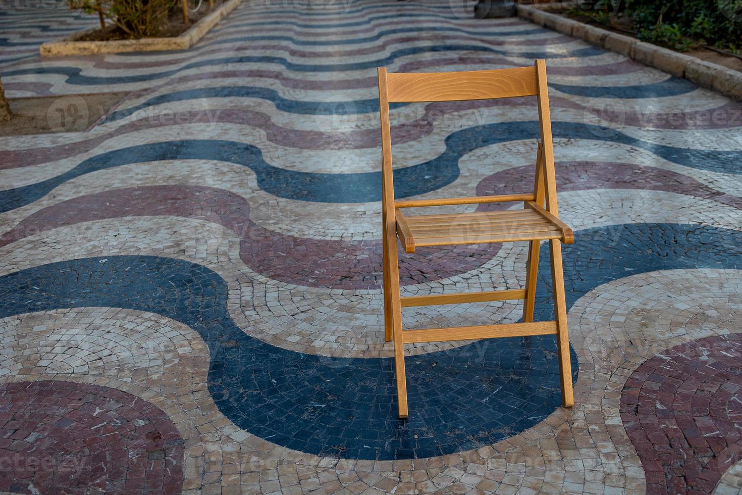 Explanada promenade in Alicante Spain landmark with wooden empty chair on mosaic photo