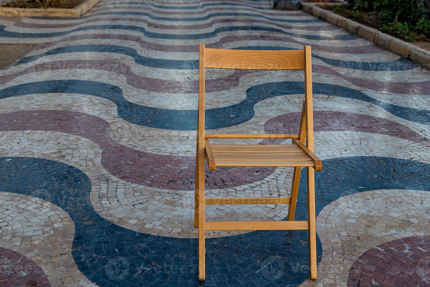 Explanada promenade in Alicante Spain landmark with wooden empty chair on mosaic photo