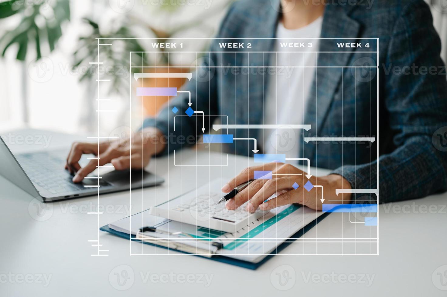 gerente de proyecto trabajando y actualizando tareas con hitos de planificación de progreso y diagrama de programación de diagramas de gantt. negocios que trabajan con teléfonos inteligentes, tabletas y computadoras portátiles en la oficina. foto