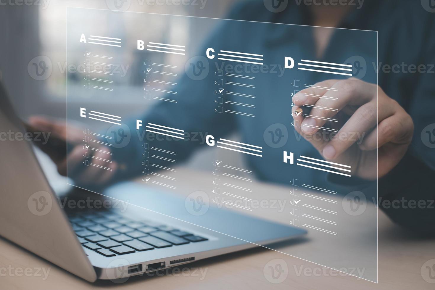Businessman using a laptop and Taking an assessment, questionnaire, evaluation, online survey online exam Choosing the right answer in exam by filling out the online survey form,Answer  test questions photo