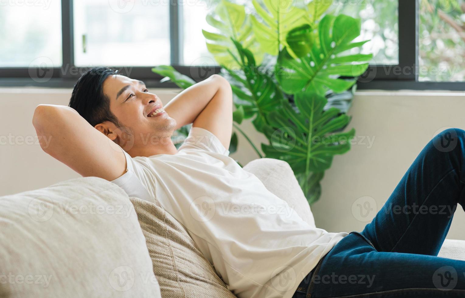 retrato de asiático hombre sentado en sofá a hogar foto