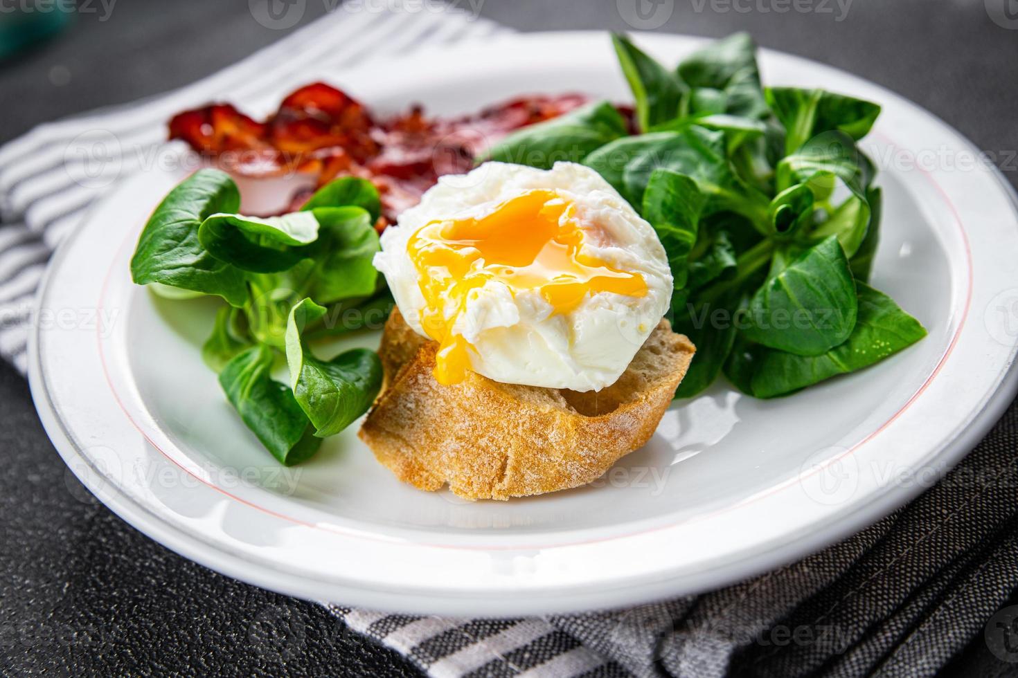 poached egg breakfast bacon, green leaves salad mix meal food snack on the table copy space food background rustic top view photo