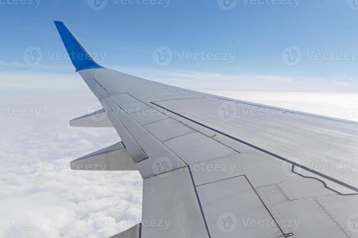 wing of aircraft above clouds photo