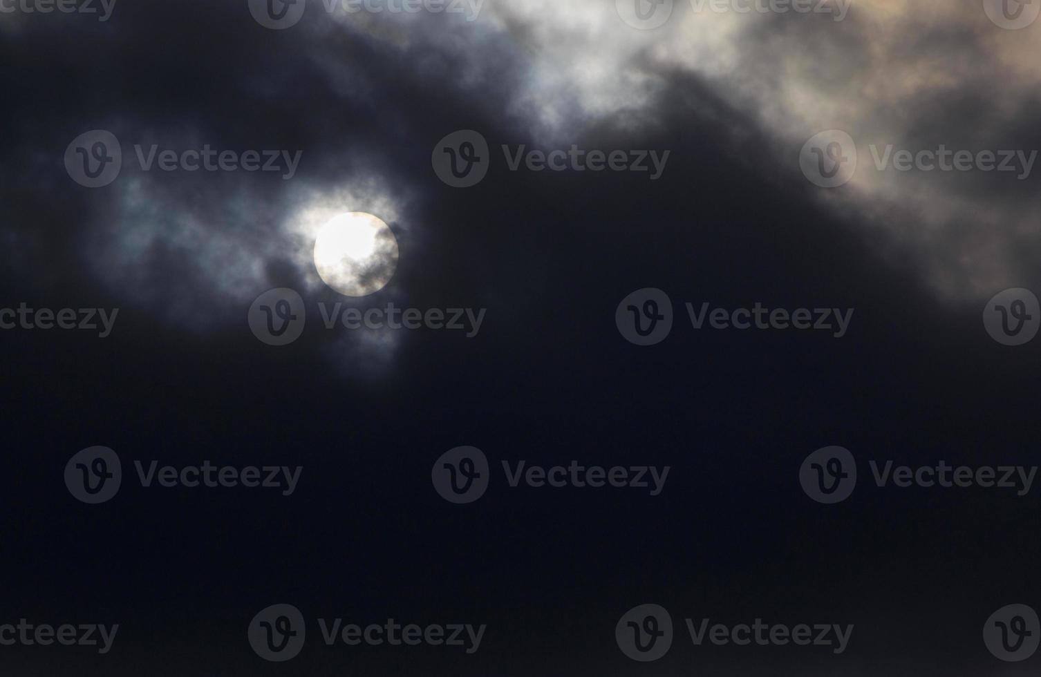 view on sun behind dark clouds photo