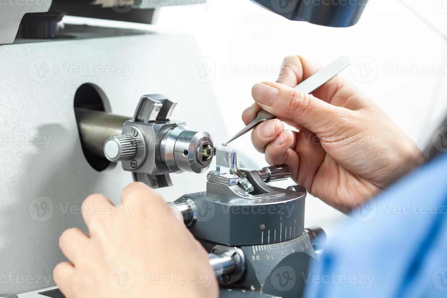 Closeup of a female scientist placing a sample on a transmission electron microscopy grid photo