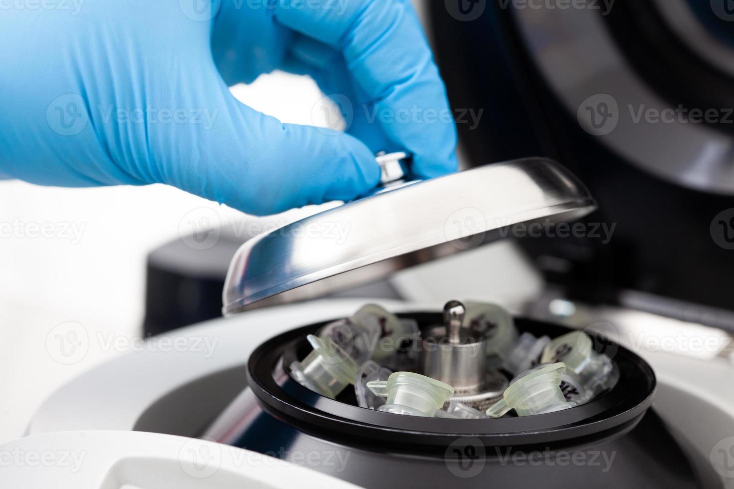 Closeup of a scientist closing an small table centrifuge filled with tubes. Spin column-based nucleic acid purification technique. Diagnosis of human papillomavirus virus infection. photo