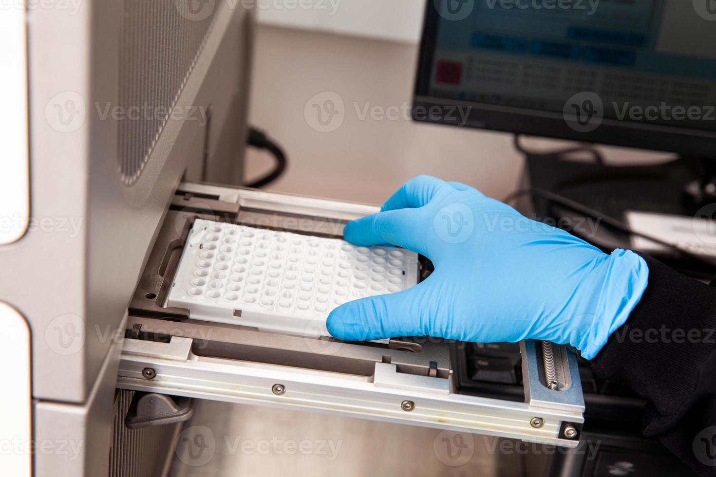 Scientist loading samples to a RT-PCR thermal cycler at the laboratory. Real-time polymerase chain reaction technique. RT-PCR technique photo