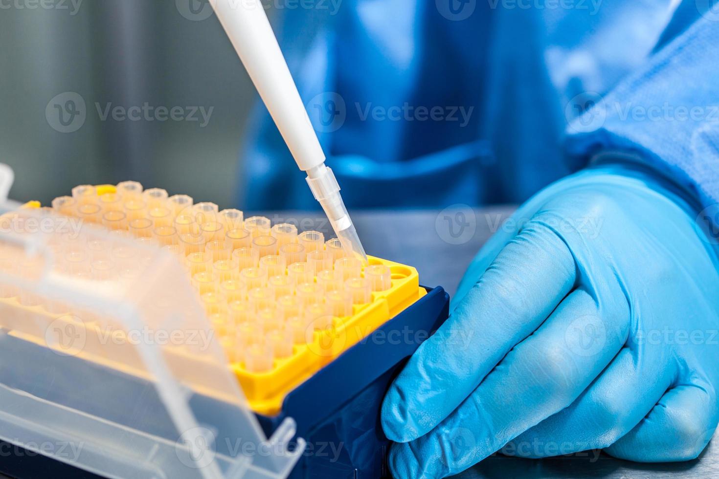 Scientist attaching a disposable tip to a micropipette photo