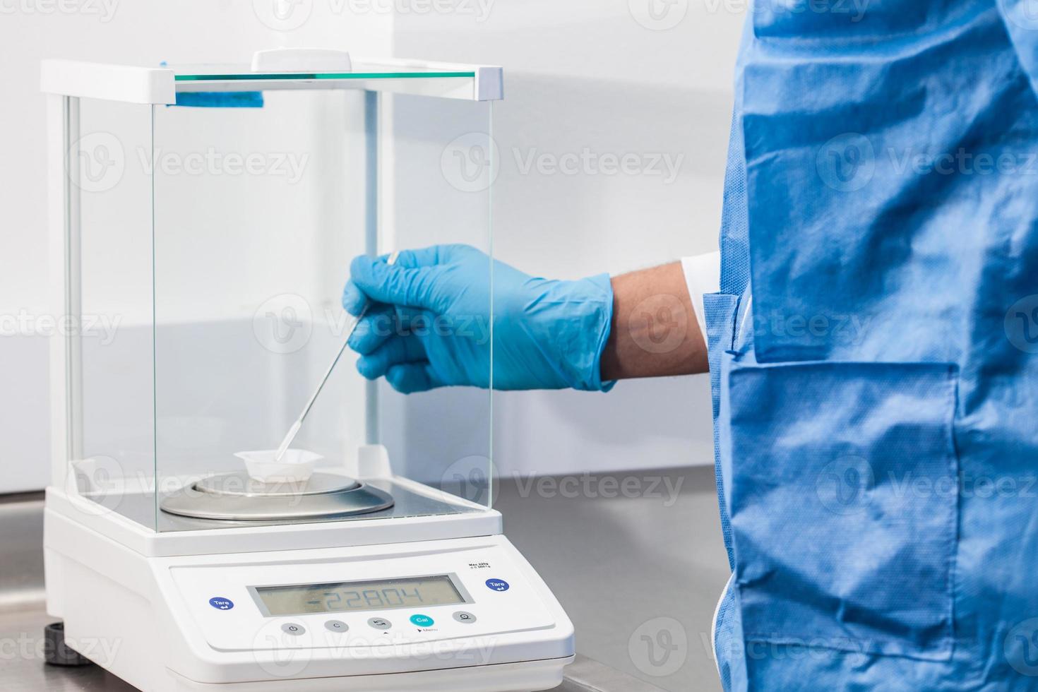 Scientist using an analytical balance at laboratory photo