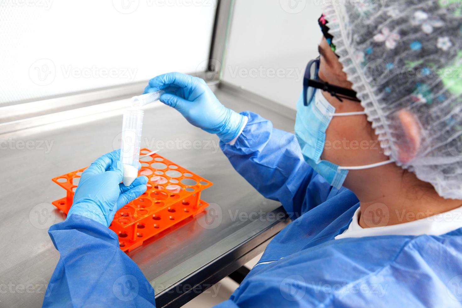 Young female scientist working in a safety laminar air flow cabinet at laboratory photo