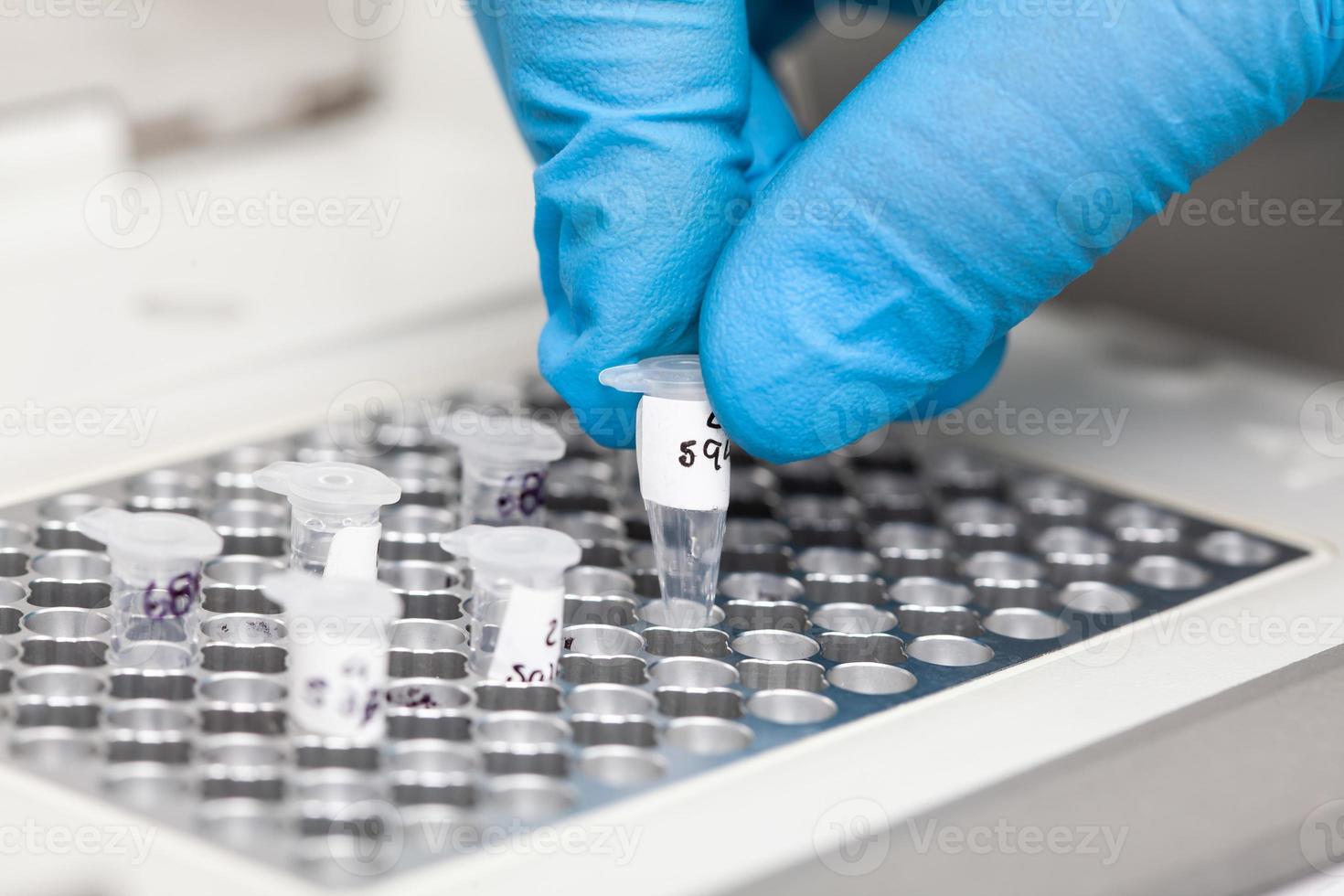 Closeup of a scientist hand while working at the laboratory with a thermal cycler. Polymerase chain reaction technique. PCR technique photo