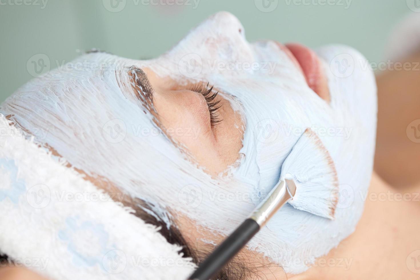 Facial mask application on young female patient photo