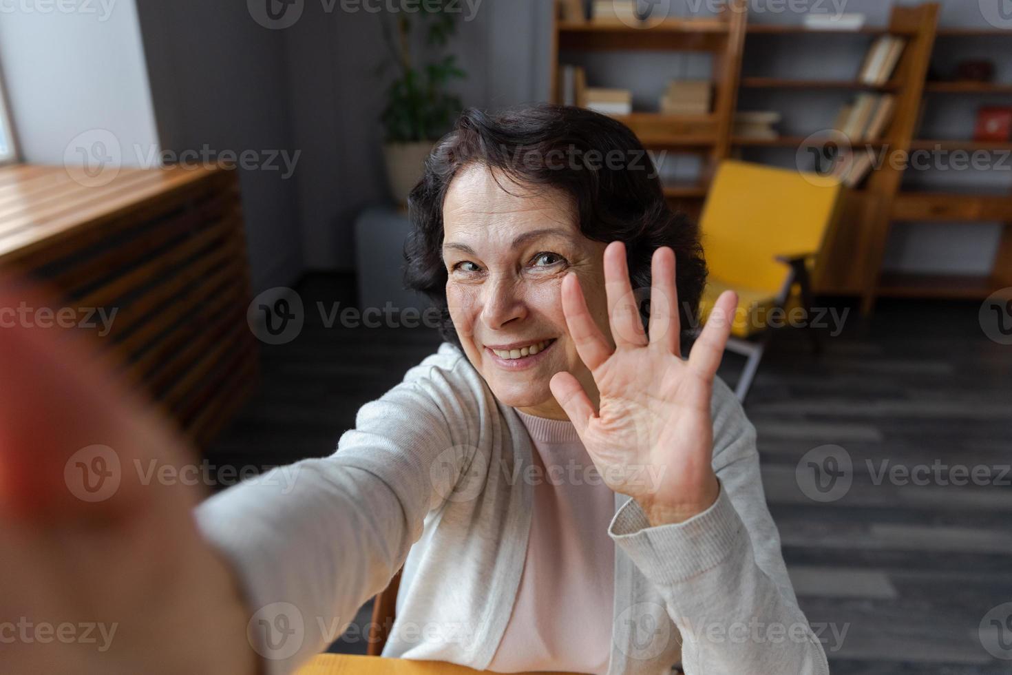Happy middle aged senior woman talk on video call with friends family. Laughing mature old senior grandmother having fun speaking with grown up children online, Headshot portrait selfie webcamera view photo