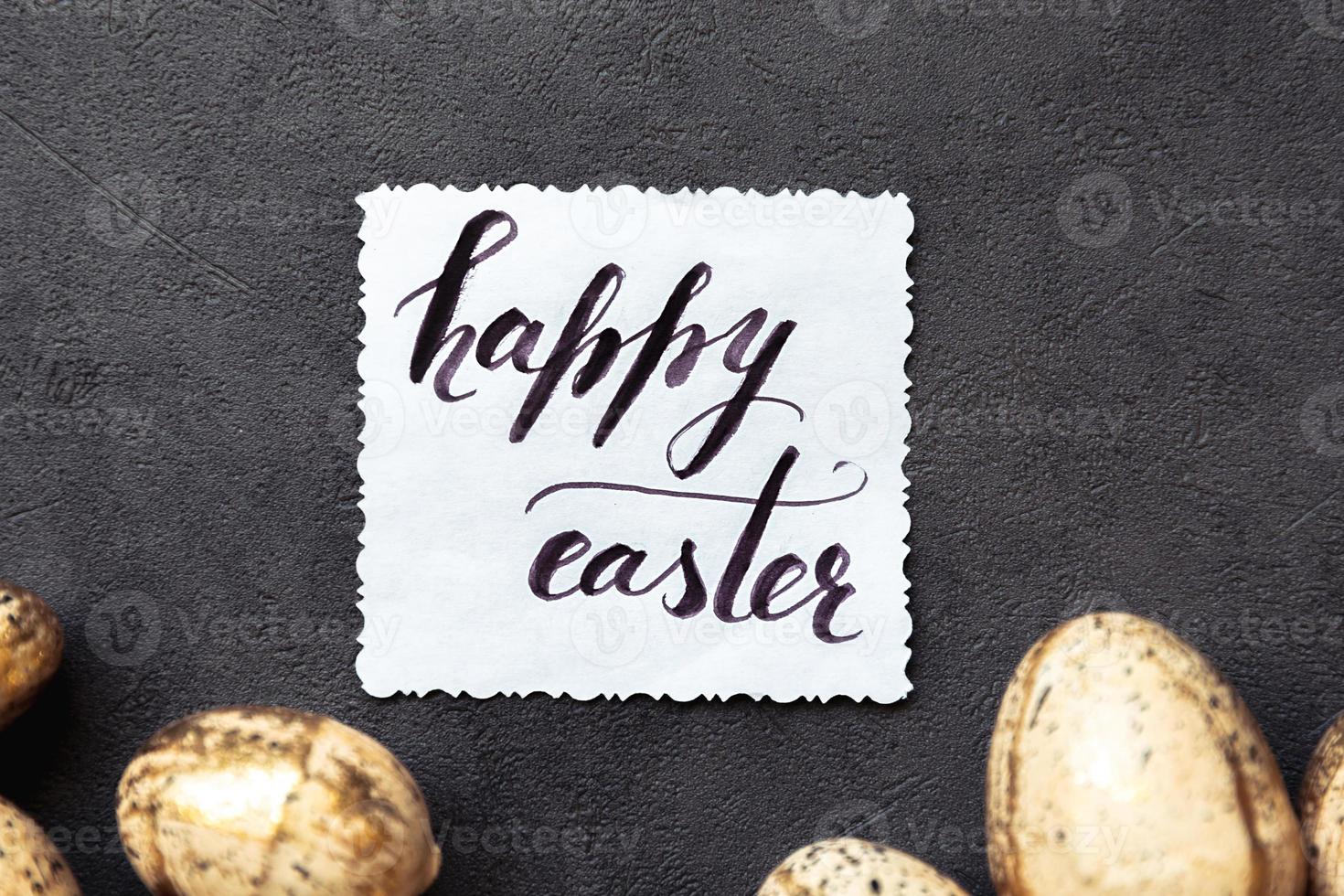 Happy Easter concept. Preparation for holiday. Golden Easter eggs Inscription HAPPY EASTER letters text on grunge scratched dark black shale background. Flat lay top view copy space. photo