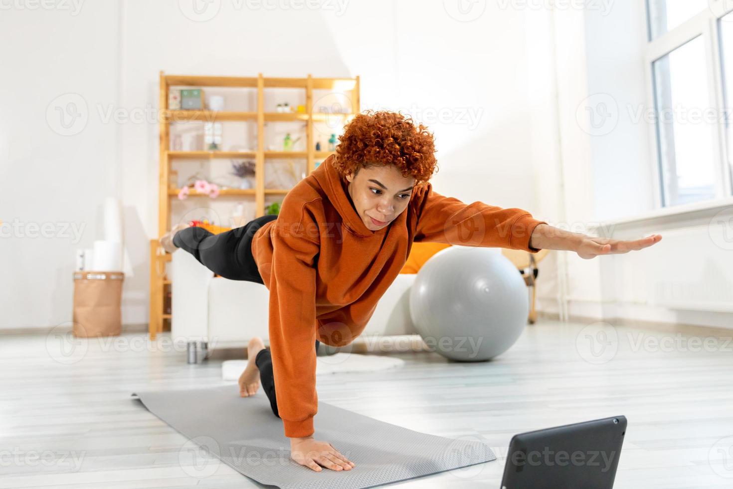 aptitud rutina de ejercicio capacitación. joven sano ajuste africano niña haciendo Deportes ejercicio en yoga estera en piso a hogar. atlético mujer en ropa de deporte tener formación rutina de ejercicio para peso pérdida. deporte y aptitud física. foto