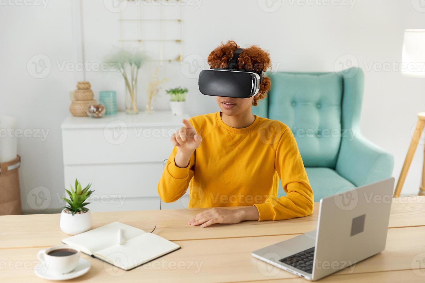 africano americano joven mujer vistiendo utilizando virtual realidad metaverso vr lentes auriculares a hogar. niña conmovedor aire durante vr experiencia en virtual realidad casco. simulación de alta tecnología videojuego concepto. foto