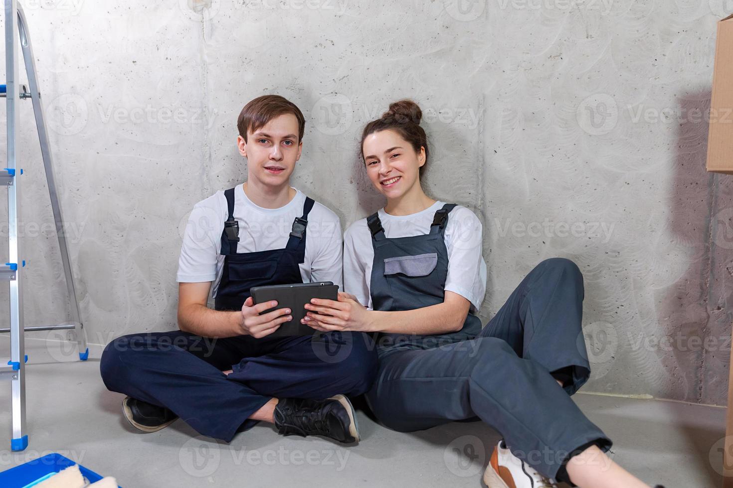 Couple in new home during repair works discussing about home design project looking repair plan on tablet. Happy family choosing new decorations and design. Home renovation DIY renew makeover concept. photo