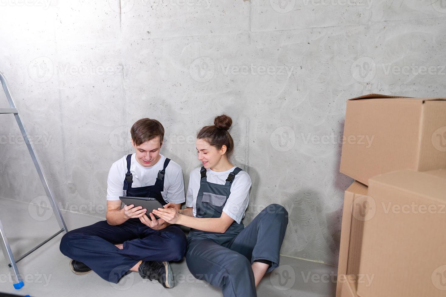 Couple in new home during repair works discussing about home design project looking repair plan on tablet. Happy family choosing new decorations and design. Home renovation DIY renew makeover concept. photo