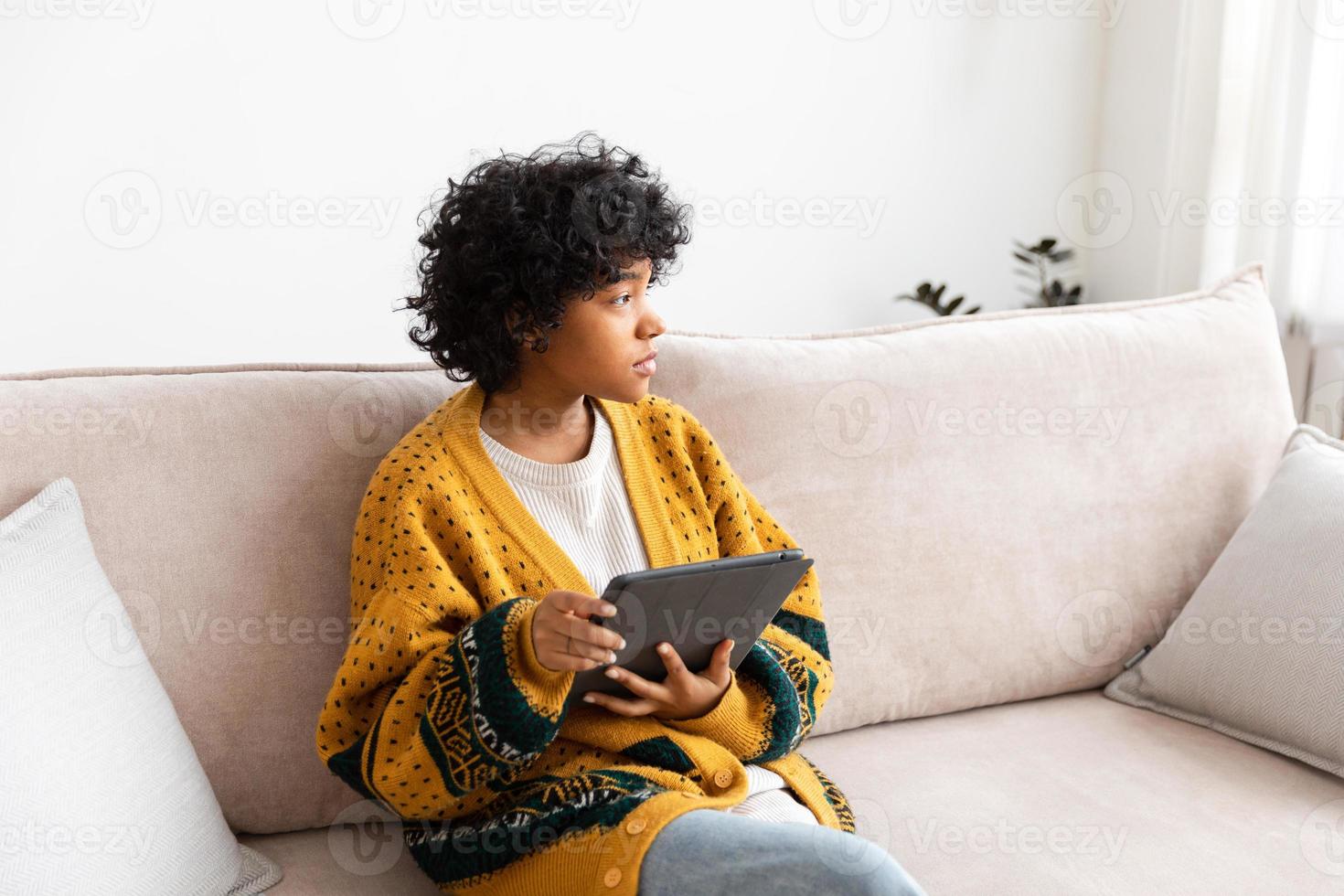 African american girl holding digital tablet touch screen typing scroll page at home. Woman with mobile tech device surfing internet using social media apps playing game. Study work shopping online. photo