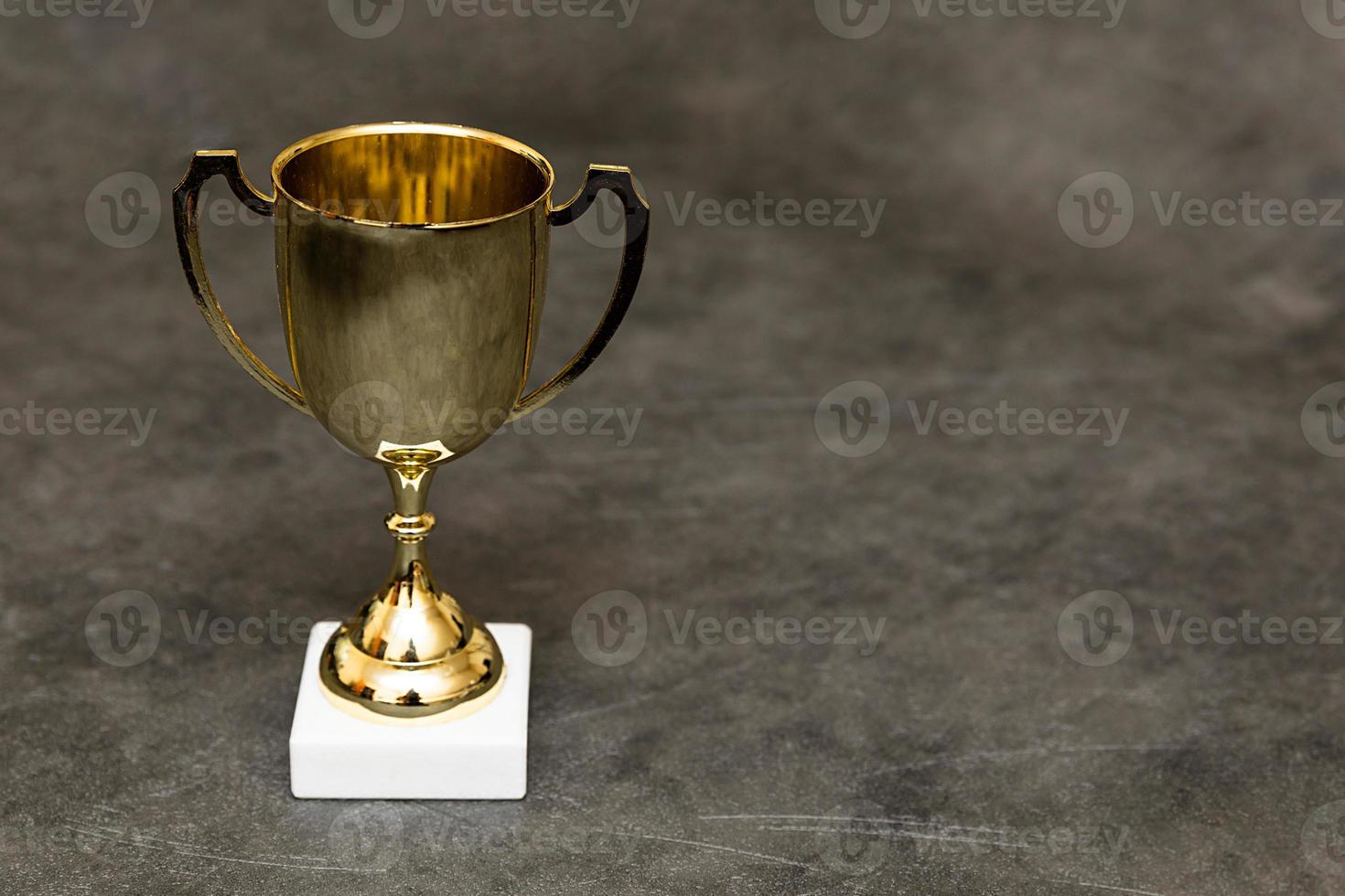 simplemente diseño ganador o campeón oro trofeo taza en hormigón Roca gris antecedentes. victoria primero sitio de competencia. victorioso o éxito concepto. parte superior ver Copiar espacio. foto