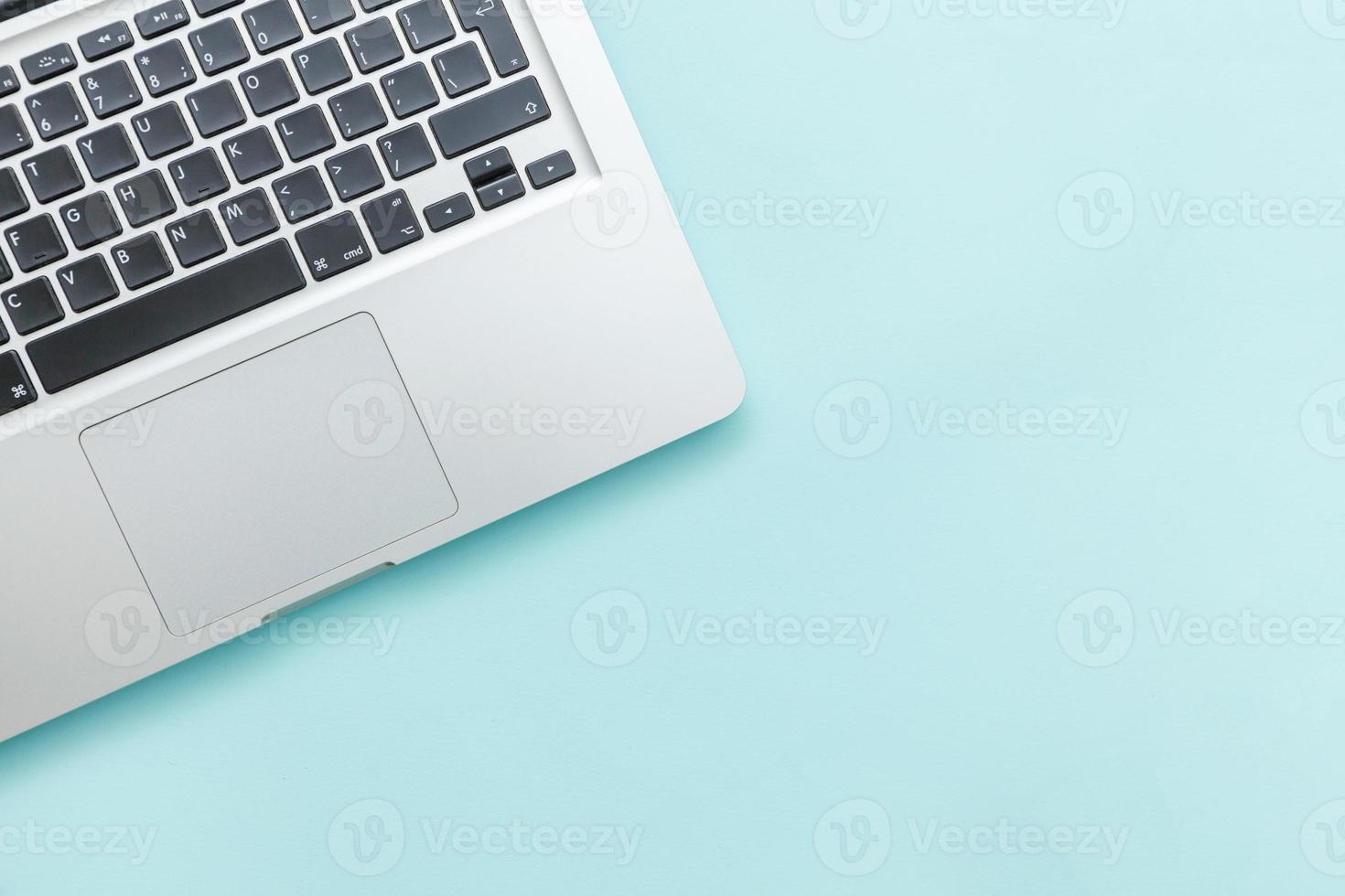 Keyboard laptop computer isolated on blue pastel desk background. Modern Information technology and sofware advances photo