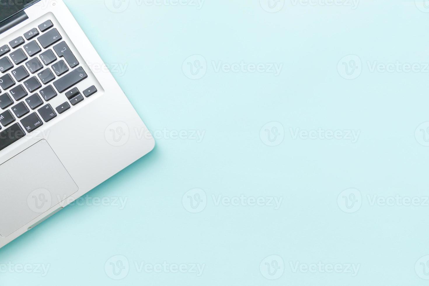 Keyboard laptop computer isolated on blue pastel desk background. Modern Information technology and sofware advances photo