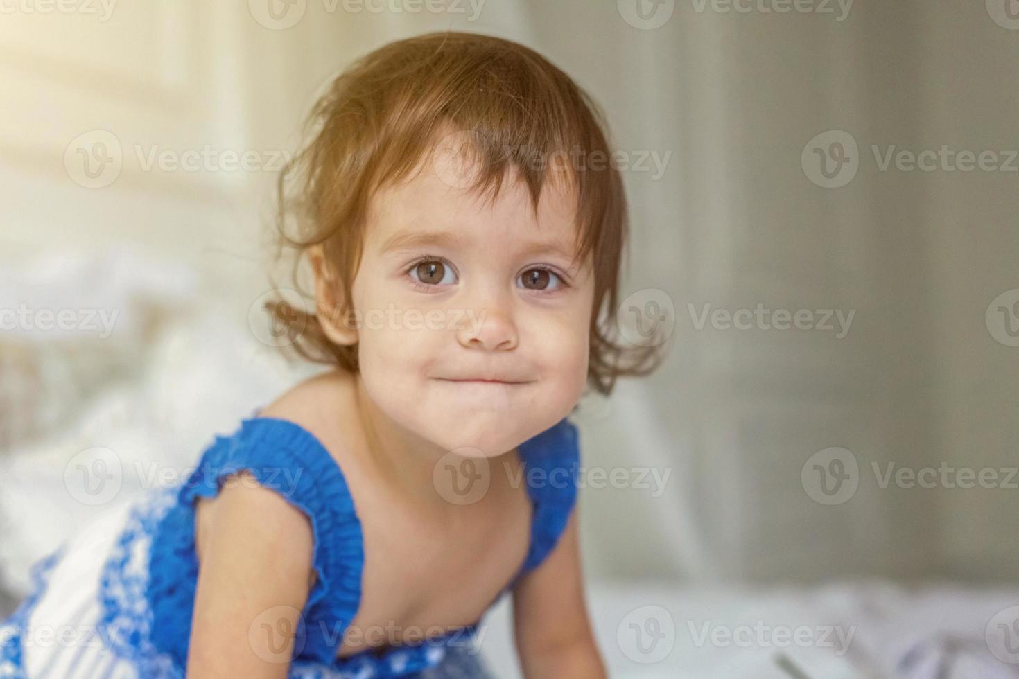 Cute little girl jumping on white bed photo