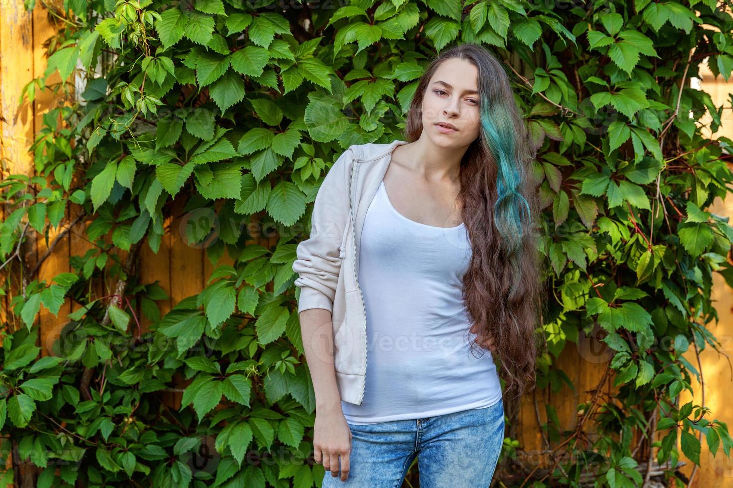 hermosa joven hipster brunete niña con largo verde pelo sonriente en parque antecedentes foto