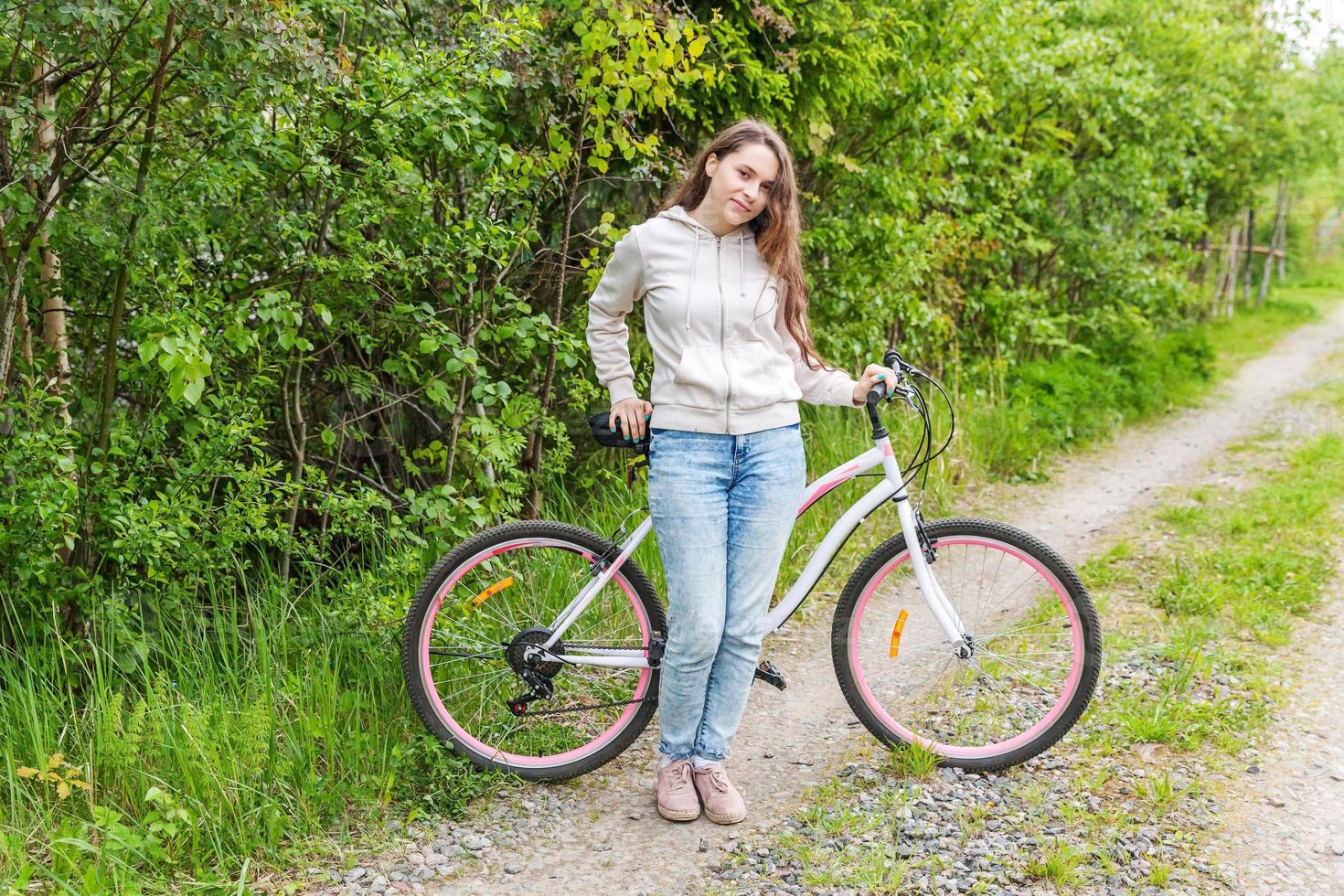 Young woman riding bicycle in summer city park outdoors. Active people. Hipster girl relax and rider bike photo