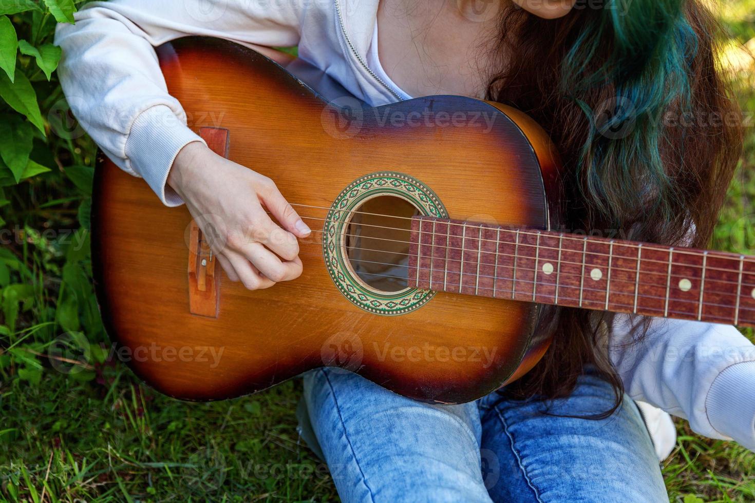 Woman hands playing acoustic guitar photo