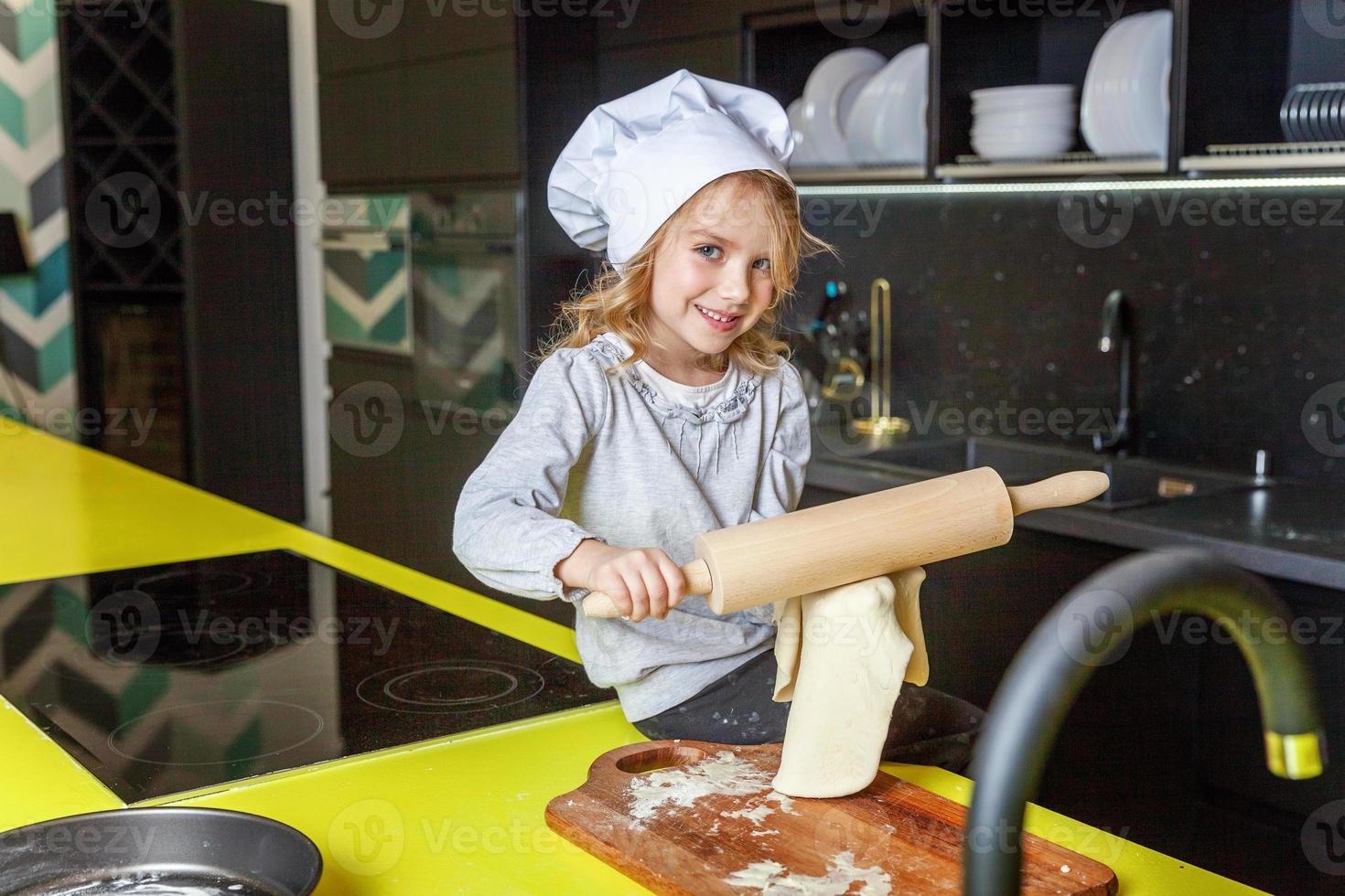 Little girl preparing dough, bake homemade holiday apple pie in kitchen photo