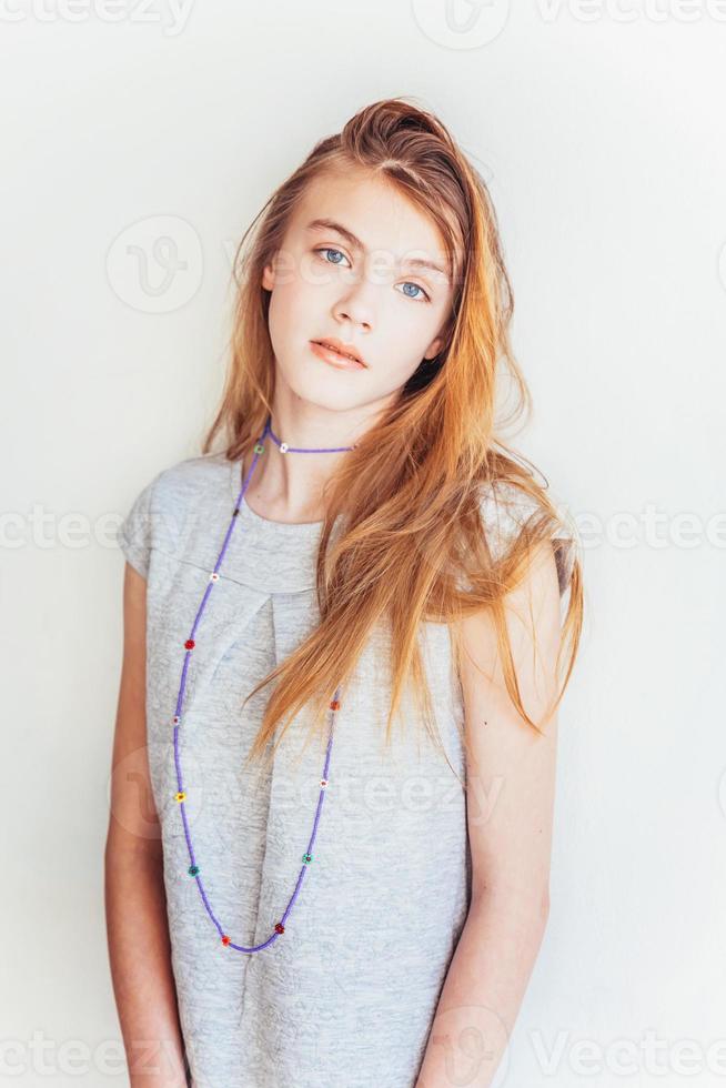 belleza Adolescente muchacha. retrato joven adolescente mujer en gris vestir en contra blanco pared antecedentes. europeo mujer. foto
