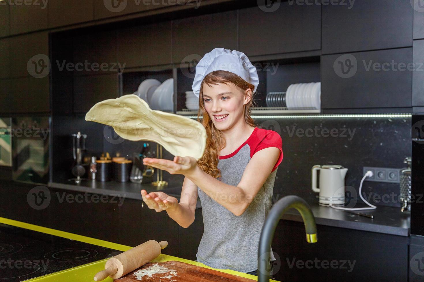 Teenage girl preparing dough, bake homemade holiday apple pie in kitchen photo