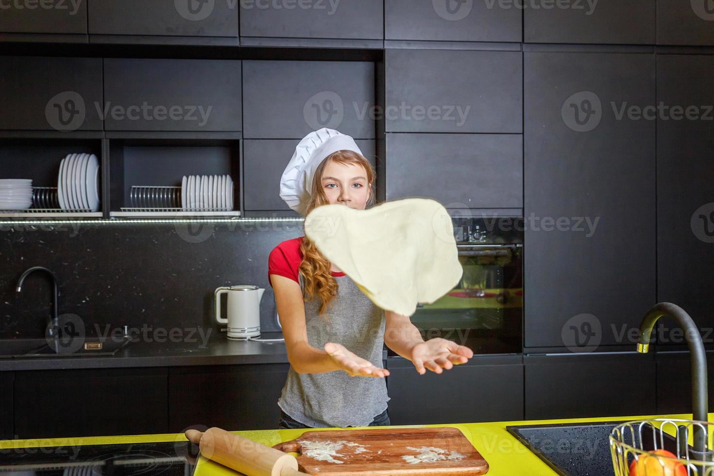 Adolescente niña preparando masa, hornear hecho en casa fiesta manzana tarta en cocina foto